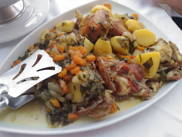 Lezzetli deniz ürünleri, balık, havuç ve patates tabağı. Geleneksel Yunan mutfağı. Lezzetli. Yanında meze ile balık..
