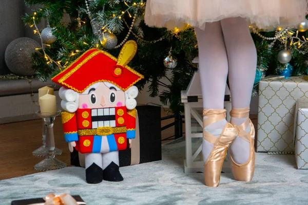 クリスマスツリーとくるみ割り人形の背景にあるバレリーナの足 — ストック写真