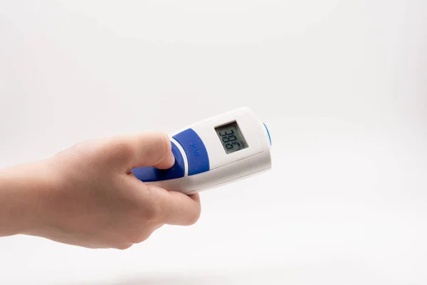 Een Witte Achtergrond Houdt Een Hand Een Elektronische Thermometer Vast — Stockfoto