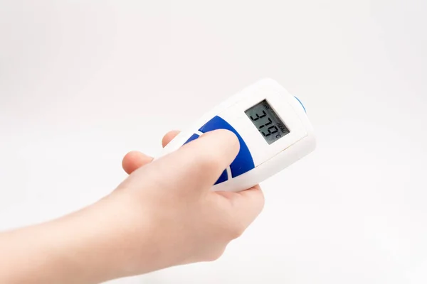 Beyaz arka planda, bir el 37.9 'luk bir elektronik termometreyi tutuyor.