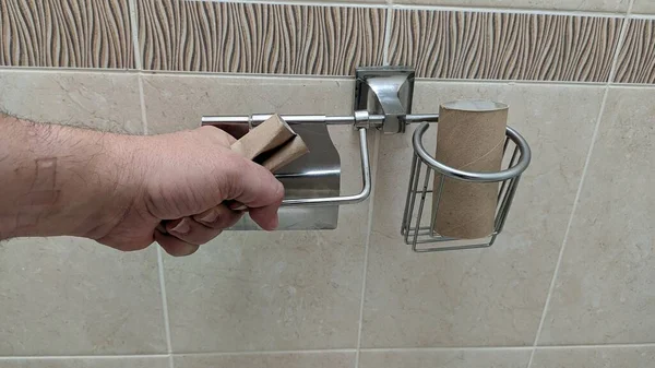 Рука Сжимает Пустой Цилиндр Туалетной Бумаги — стоковое фото