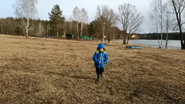 Річний Хлопчик Блакитній Куртці Біжить Нас Тлі Пустельного Пляжу Повільний — стокове відео