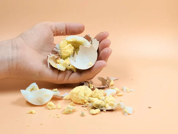 Rozdrcené vejce a skořápka leží na béžovém pozadí. — Stock fotografie