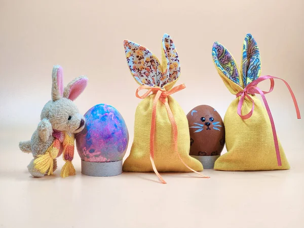 Bej bir arka planda Paskalya Tavşanı ve Paskalya Torbası.