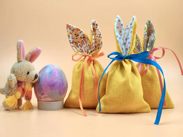Lapin de Pâques et sacs de Pâques sur fond beige . — Photo