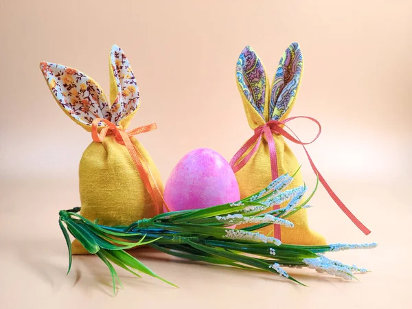 Lapin de Pâques et sacs de Pâques sur fond beige . — Photo