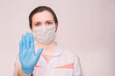 Tıbbi maskeli ve mavi eldivenli kız Coronavirus 'u durdurmak için el ele durduğunu gösteriyor. Hayatımızda koronavirüs yok..