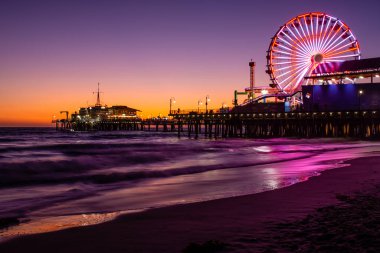 Santa Monica İskelesi, renkli günbatımında. Sudaki güzel yansımalar
