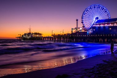 Santa Monica İskelesi, renkli günbatımında. Sudaki güzel yansımalar