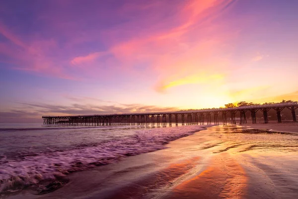 Pier al tramonto California Highway 1 con nuvole viola e bei riflessi — Foto Stock