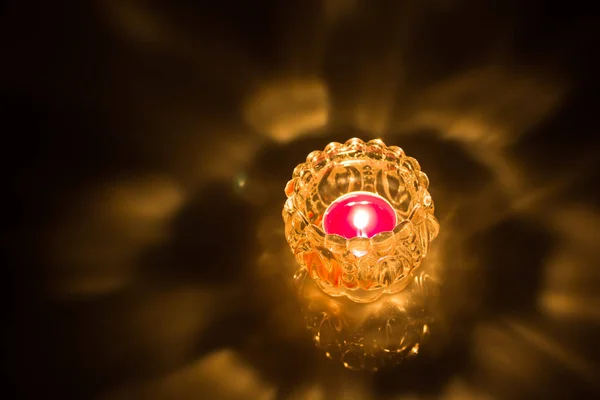 Siyah arka plan üzerine cam kavanoz içinde mum yanan ateş yukarıya kapatmak