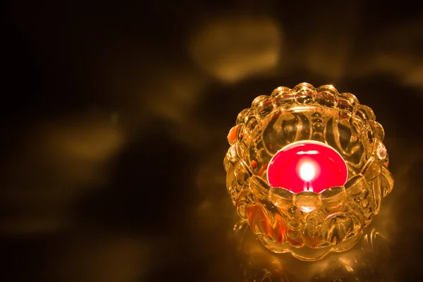 Siyah arka plan üzerine cam kavanoz içinde mum yanan ateş yukarıya kapatmak