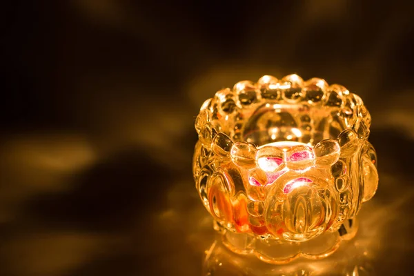 Siyah arka plan üzerine cam kavanoz içinde mum yanan ateş yukarıya kapatmak