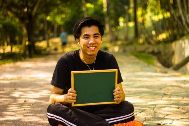 Aktif genç Malay adam mini yazı tahtası park holding 