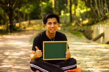 Aktif genç Malay adam mini yazı tahtası park holding 