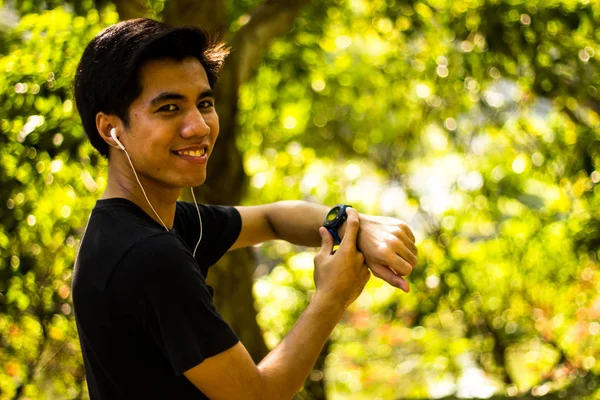Sorrindo Jovem Malaio Homem Usando Relógio Antes Correr Parque — Fotografia de Stock