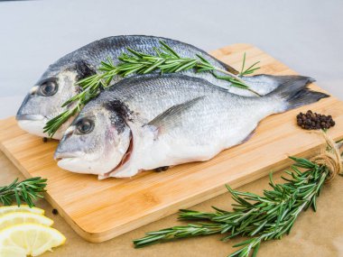 Limon, biber ve biberiye gibi malzemeli çiğ balık. Taze pişmemiş dorado ya da çipura balığı. Akdeniz mutfağı. Sağlıklı ve diyet gıda konsepti. Sparus aurata.