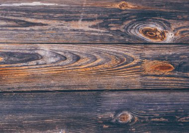 Koyu ahşap doku. Siyah turuncu tahta desenli, düğümlü kütükler. Retro ahşap çit, masa yüzeyi. Doğal renk. Yıpranmış kereste arka planı. Eski kırık kalaslar.