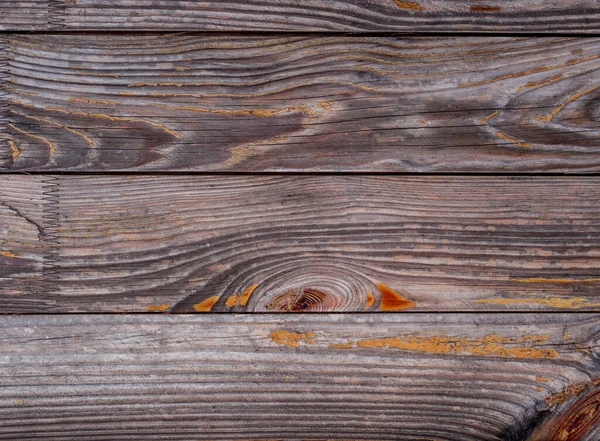 Old rich wood grain texture with knots. Vintage wooden background. Gray with orange boards. Timber fence, desk surface. Natural brown color. Weathered table.