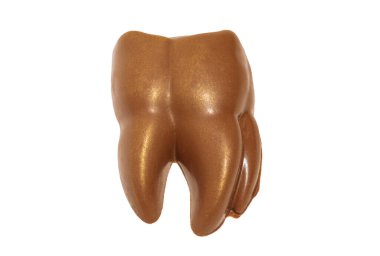 Sütlü çikolatadan yapılmış komik kahverengi dişler, dişçi için beyaz bir arka planda altın püskürten yakın çekim izolasyonu.