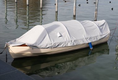 Günbatımında beyaz tekne çarşaflı beyaz kahverengi balıkçı teknesi.