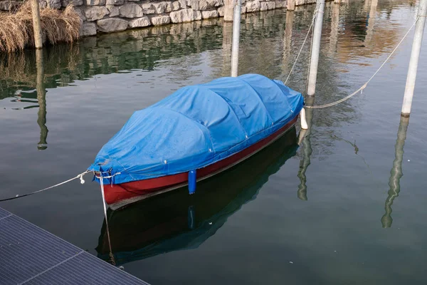 Turkuaz suda kırmızı balıkçı teknesi. Mavi tekne kaplamalı. Günbatımında, gündüzleri.