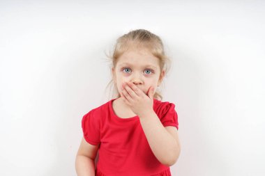 Pembe elbiseli küçük bir kız eliyle ağzını kapadı. Konuşmaktan kork. Çocuk eğitiminin sosyal teması