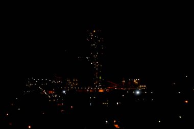 Geceleri bir çimento fabrikası, fabrikayı aydınlatan bir lambanın ışıkları. Sanayi Tesisi.