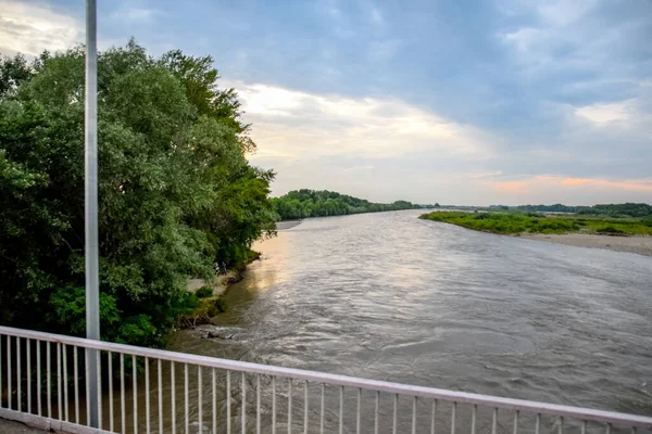 Passing over the bridge over the river. The landscape of the river, the surface and the trees of the river\'s waterplain.