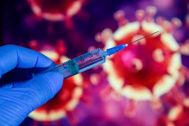 Coronavirus aşısı. Tıbbi eldivenlerdeki bir el, aşıyı ve şırıngayı koronavirüsün arka planına karşı tutar. covid-19,
