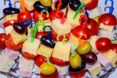 Plastik çubuklar üzerinde sebze ve peynirle servis edilmiş bir salata..