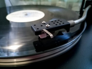 Vinil çalar. Plakası vinil oynatıcının üzerinde..