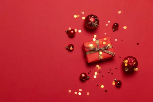 圣诞作文，红色背景上有红纸礼品盒、彩带、糖果和不同尺寸的圣诞球. — 图库照片