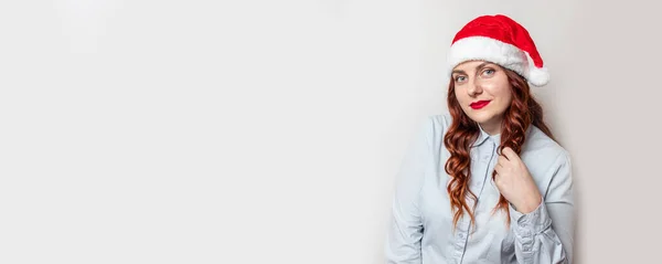 Sonriente hermosa niña gorda con el pelo rizado y sombrero de santa expresando emociones felices. Descuentos y venta de vacaciones de Navidad de temporada . —  Fotos de Stock