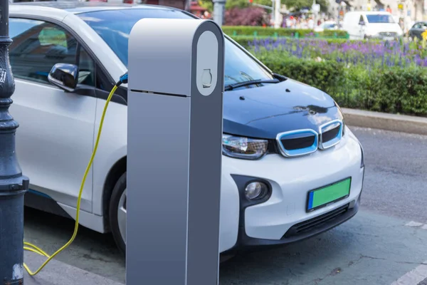 Electric car charging station. Close up of the power supply plugged into an electric car being charged. — Stock Photo, Image