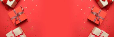 Kırmızı arka planda fiyonklu kırmızı hediye kağıdına sarılı sürpriz kutular. Tatil ve tebrik kartı kavramı. Boşluğu kopyala.