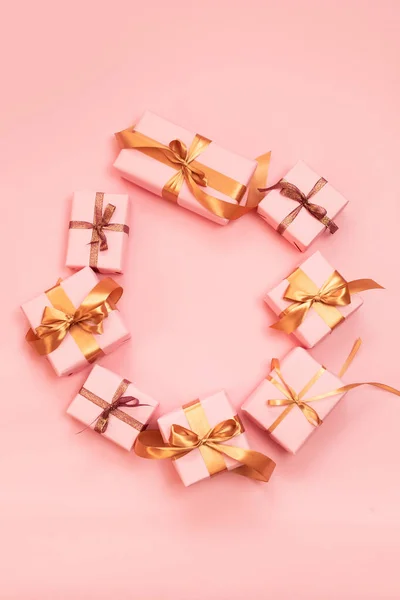 Weihnachten oder Neujahr Banner mit Papier rosa Geschenkboxen mit glänzenden goldenen Bändern auf rosa Hintergrund dekoriert. — Stockfoto