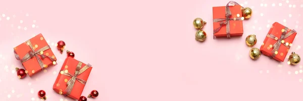 有精美礼品盒、金光闪闪的缎带和粉色背景的带有复制空间的红色球的创意圣诞背景. — 图库照片