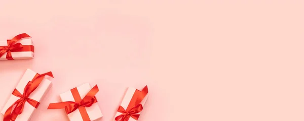 Composición del día de San Valentín o pancarta con regalos sorpresa, lazo rojo sobre un fondo rosa. Plano, vista superior, espacio para copiar . — Foto de Stock