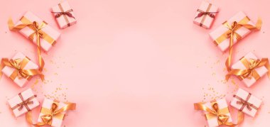 Sevgililer Günü kompozisyonu ya da pembe arka planda altın fiyonklu sürpriz hediyeler. Düz konum, üst görünüm, kopyalama alanı.