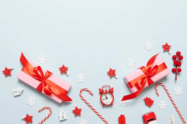 Boldog karácsonyt és újévet gratulációs kártya rózsaszín papírdobozok, piros szalagok, csillogás, autós játék, csillagok és piros bogyó a kék háttér fénymásolás. Karácsony, újév. Lapos feküdt kreatív id — Stock Fotó