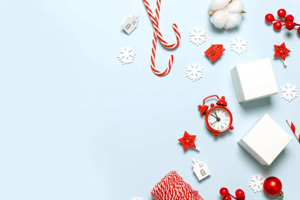 Feliz Navidad y Año Nuevo tarjeta de felicitación con cajas de papel, reloj rojo, desenfoque brillo, juguete para el coche, estrellas y baya roja sobre fondo azul —  Fotos de Stock