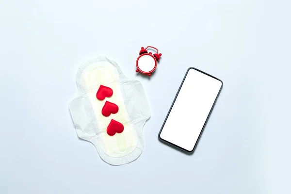 Menstruationsperiod koncept. Smal bomull menstruation pad med röd kärlek form som bloddroppar, smartphone mall på blå bakgrund — Stockfoto