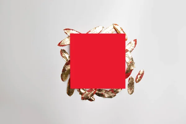 Ünnepi minimalista koncepció piros négyzet alakú sablon arany levelek szürke háttér. — Stock Fotó