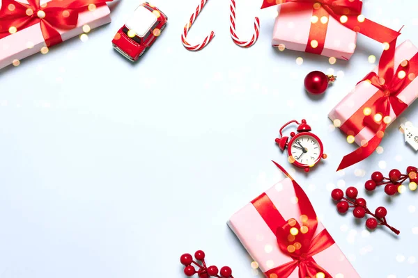 圣诞快乐佳节贺卡或横幅上有礼品、红色饰物、汽车玩具、糖果手杖和蓝色背景的闪光 — 图库照片