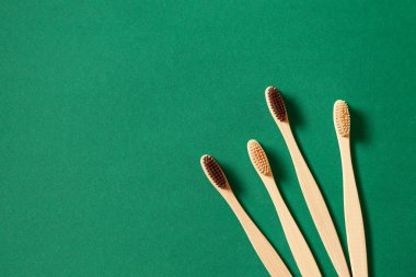 Yeşil zemin üzerinde eko bambu ağacı diş fırçaları ile üst görünüm veya düz konsept
