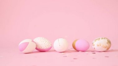 Pembe arka planda süslü yumurta üzerine pembe altın konfeti damlaları. Minimum tatil konsepti. Gamalı haç paskalya kartı