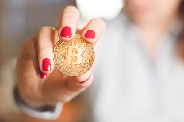 Μια γυναίκα κρατά ένα χρυσό κέρμα σε bitcoin τα χέρια της — Φωτογραφία Αρχείου