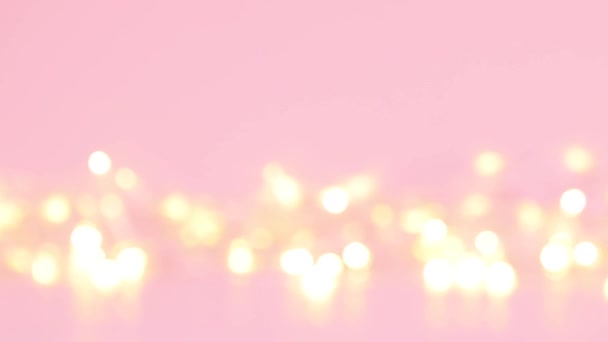 Luci d'oro. Abstract oro sfocato bokeh luci su uno sfondo rosa. — Video Stock