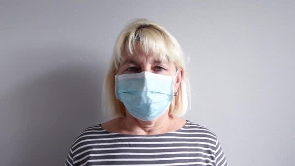 Взрослая женщина в медицинской маске кашляет — стоковое видео